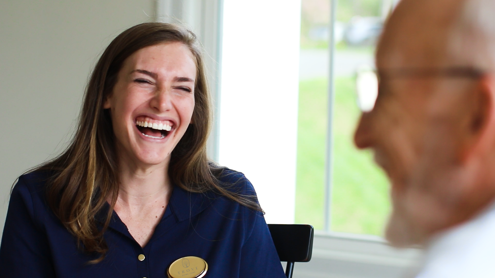 in-home care provider laughing with elderly client